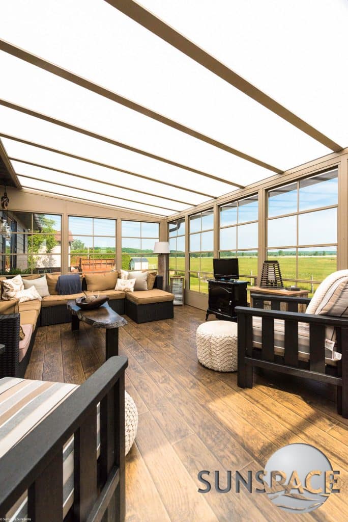Modern acrylic patio cover providing shade over a backyard deck in Northern Ohio