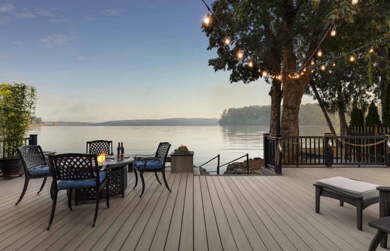 thermadeck solution from deck and shade solution overlooking a lake with lights strung on a tree.