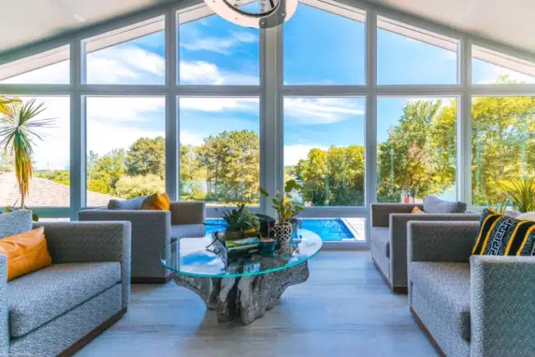 sunroom overlooking a pool on a sunny day
